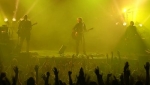 The band bathed in yellow and green lights