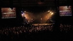 The crowd watching the band via video screens