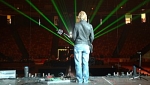 Laser beams shine as Martin looks out over an empty arena